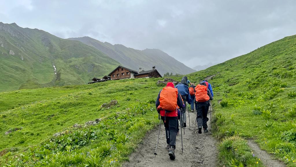 Randonneurs sous la pluie en direction du refuge